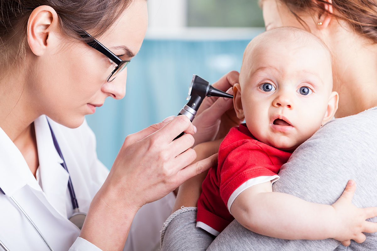 Doctor examining baby's ears