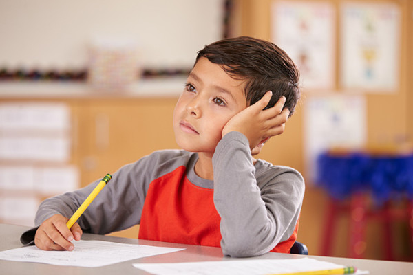 Boy distracted at desk in class