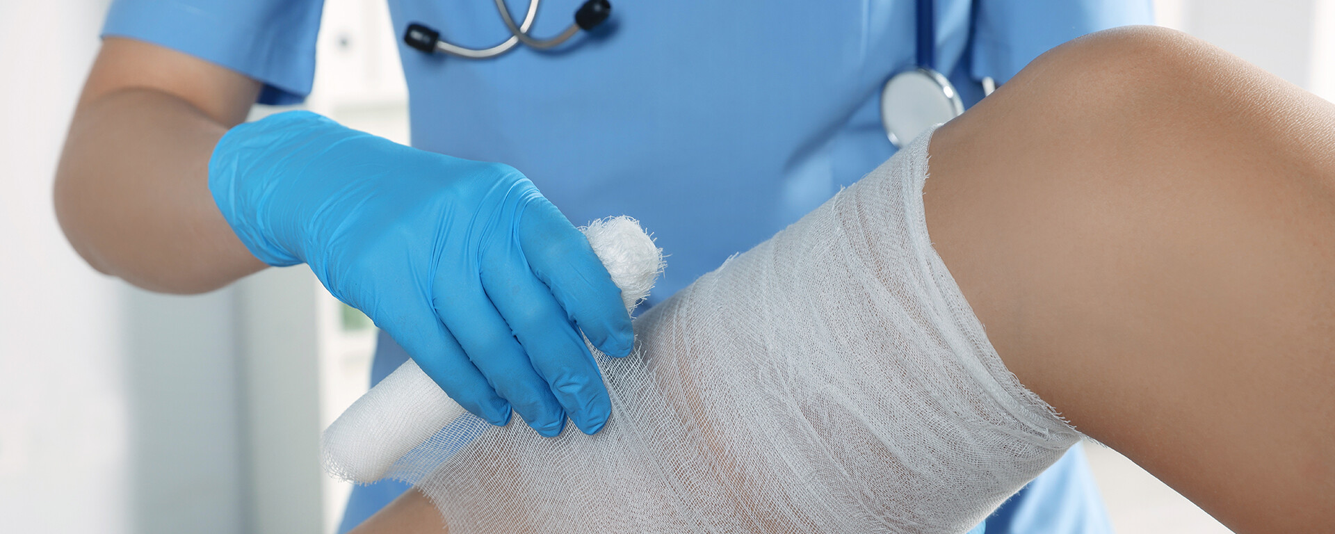 Doctor placing bandage on knee