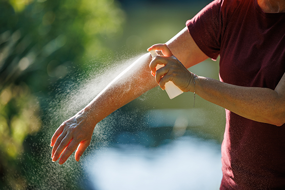 Applying insect repellent on arm